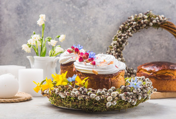 Fototapeta na wymiar Easter Cake - Russian and Ukrainian Traditional Kulich or Brioche on a light stone background. Paska or Panettone Bread and spring flowers