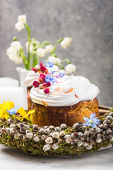 Easter Cake - Russian and Ukrainian Traditional Kulich or Brioche on a light stone background. Paska or Panettone Bread  and spring flowers