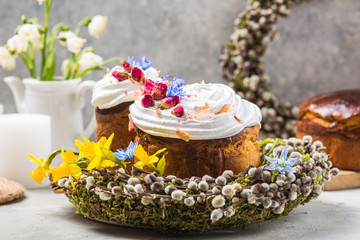 Obraz na płótnie Canvas Easter Cake - Russian and Ukrainian Traditional Kulich or Brioche on a light stone background. Paska or Panettone Bread and spring flowers