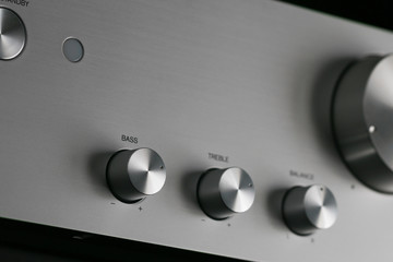 Close-up of Control Knobs on a Silver Metallic Amplifier