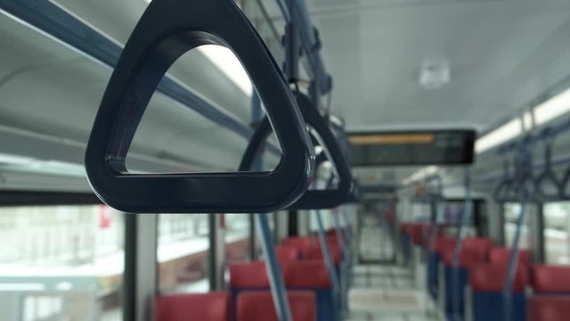 Close up view row of hand handles inside empty modern train. Public transport