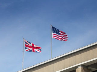 USA and UK flags in the blue sky / English and American flag waving - U.S.A. and UK