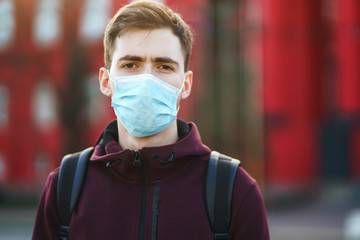 Portrait of men in protective sterile medical mask on her face on the street city. The concept of...