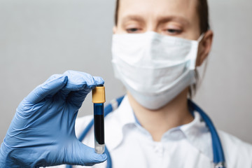 Doctor holding test tube with blue fluid