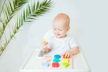 Child little boy playing wooden toys at home or kindergarten