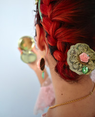 Chica mirandose al espejo con broche en el pelo rojo y con peinado de esposa
