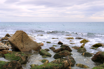 Coast of the Irish Sea with stone boulders.
