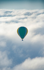 Globo aerostático volando en medio de las nubes.