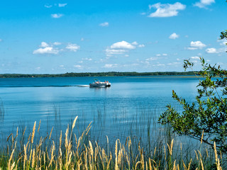 Beautiful Minnesota lake scene from the shore includes a passing poWooden bird watching shelter hut...