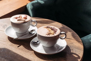 Cocoa in large white cup on table in cafe. Cocoa with marshmallows, peppers.