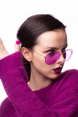 girl in a purple sweater, purple glasses with purple lipstick on her lips