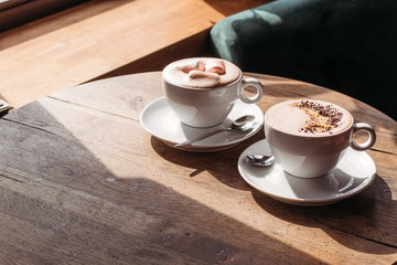 Cocoa in large white cup on table in cafe. Cocoa with marshmallows, peppers. Place for text.