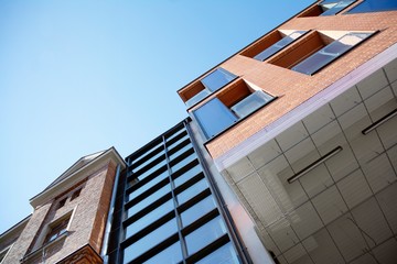 Exterior of new apartment buildings on a blue cloudy sky background. No people. Real estate business concept.