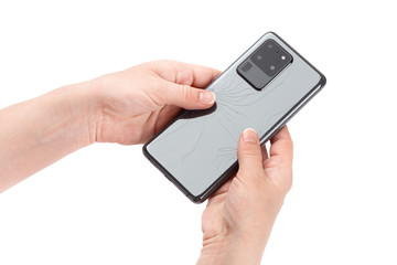 Smartphone with a broken back cover in hands on a white background.