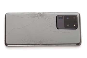 Smartphone with a broken back cover on a white background.
