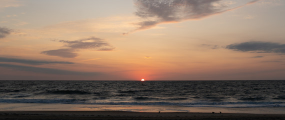 Fototapeta na wymiar sunrise 1/2 way at the shoreline