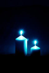 burial concept with two burning candles against black background