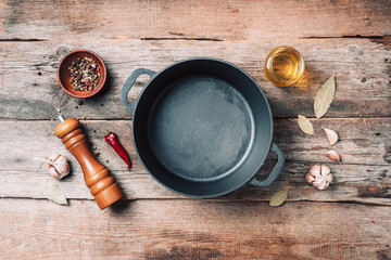 Empty iron pot and kitchen utensils on wooden background. Top view. Copy space. Healthy, clean food and eating concept. Zero waste. Cooking frame