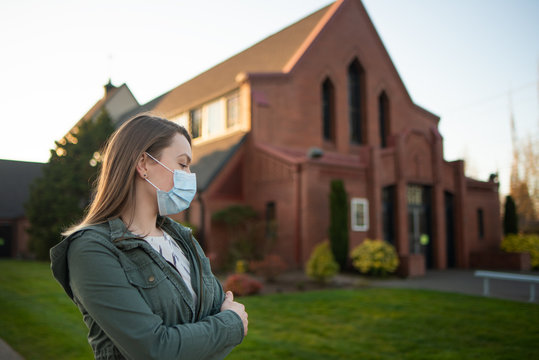 Girl In A Mask On The Background Of An Empty Street In The USA Coronavirus. Against The Background Of Church, Crown Virus, Flash. Faith And Religion. For News And Media