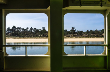 Una playa solitaria vista a través de desventajas de un barco de transporte 