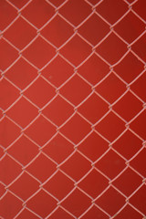 Maschendrahtzaun vor roter Wand - Hintergrund