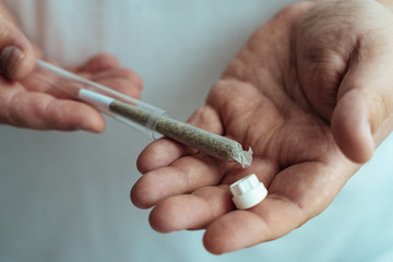 Weed joint in plastic tube in male hand. Marijuana or Cannabis ready to smoke. Amsterdam famous...