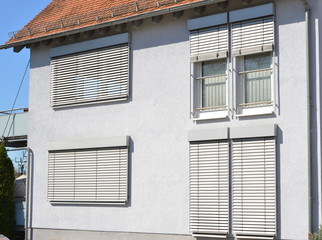 Moderne Fenster in einer gemauerten, verputzten und gestrichenen Fassade eines modernen Wohnhauses