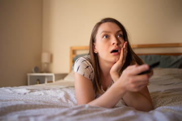 The quarantined girl watches TV at home, consuming services. Rest at home, self-isolation