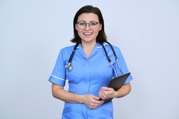 Mature female medical worker with digital tablet