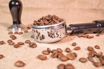 Holder and tamper with coffee beans. Fragrant coffee beans.