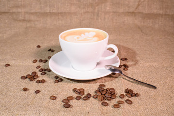 Tasty and fragrant cappuccino on the background of the canvas.