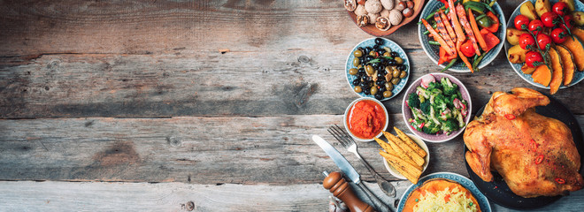 Roasted whole chicken or turkey, pumpkins, corn and harvest vegetables with kitchen knife and...