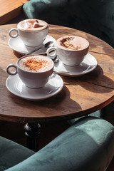 Cocoa in large white cup on table in cafe. Cocoa with marshmallows, peppers and cinnamon.