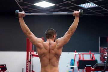 Naklejka premium Hard Core Bodybuilding. Muscular athletic bodybuilder fitness model training arms with dumbbells in gym. Concept sport photo of exercises in gym