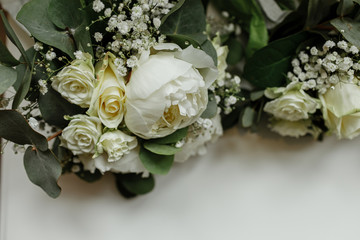 Obraz na płótnie Canvas wedding bouquets of white roses and greens for bridesmaids on a white table. brides morning. wedding accessories. selective focus