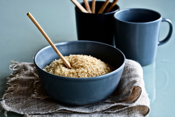 heap of raw rice in the terracotta bowl