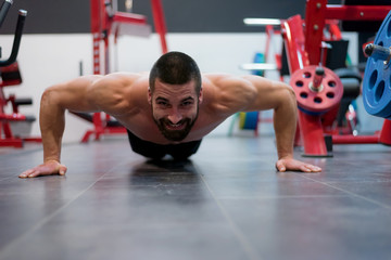 Hard Core Bodybuilding. Muscular athletic bodybuilder fitness model training arms with dumbbells in gym. Concept sport photo of exercises in gym