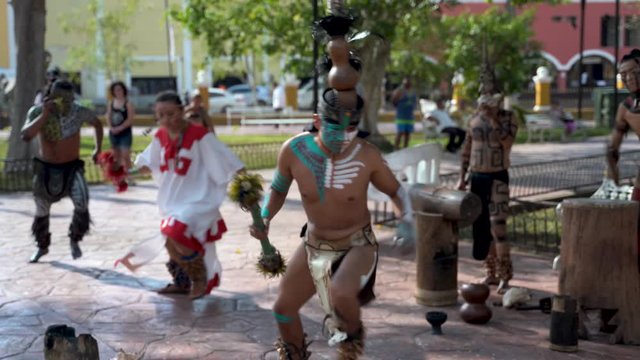 Closeup of Mayan dancers performing to live drums outside in a park in Valladolid, Mexico.
