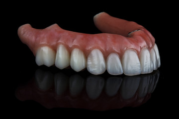 excellent dental prosthesis for the upper jaw on black glass with reflection