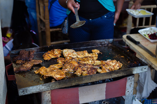 barbecue of chicken pieces and kitchen utensil in typical andean town in peru celebrating a party called "pollada", yungay