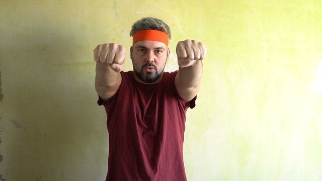 Bearded man against the wall. Good mood. Engaged in martial arts. Repair work in the room. Frick.