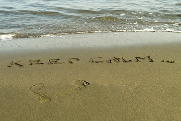 Footprints and words on beach sand