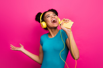 Photo of pretty funky dark skin lady hold telephone listen music modern earphones sing smart phone...