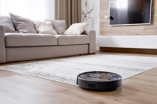 Robotic vacuum cleaner on the floor in cozy modern living room