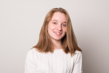 Cheerful teen girl. Studio image of a cute smiling young girl on a gray background.