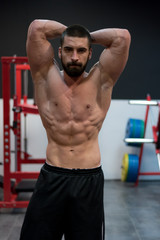 Fototapeta na wymiar Fitness model Man posing in the gym. Handsome man with big muscles, posing at the camera in the gym.