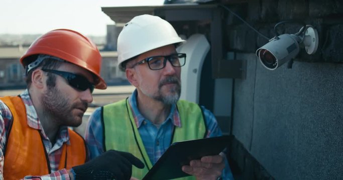 Engineer and technician discussing about security camera
