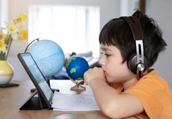 Kid self isolation using tablet for his homework, Child doing  using digital tablet searching...