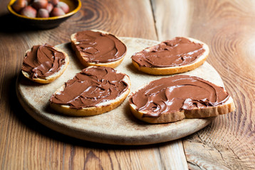 Sandwiches with chocolate cream on wood.