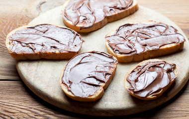Sandwiches with chocolate cream on wood.